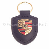 Porsche-Schlüsselanhänger mit Farbwappen und schwarzem Lederanhänger